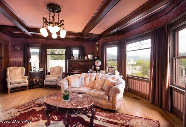 living room featuring light hardwood / wood-style floors, coffered ceiling, a chandelier, and beamed ceiling