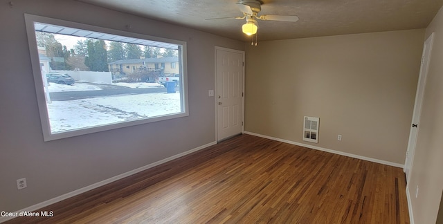 empty room with a textured ceiling, ceiling fan, hardwood / wood-style floors, and heating unit