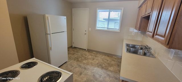 kitchen with backsplash, sink, and white appliances