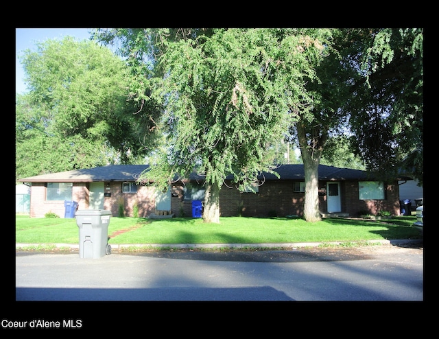 ranch-style home featuring a front lawn