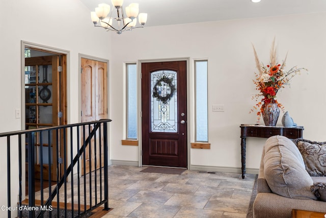 entrance foyer with light tile floors, a notable chandelier, and plenty of natural light