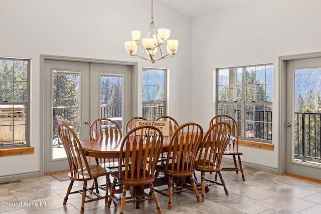 tiled dining room featuring a healthy amount of sunlight, a notable chandelier, and high vaulted ceiling