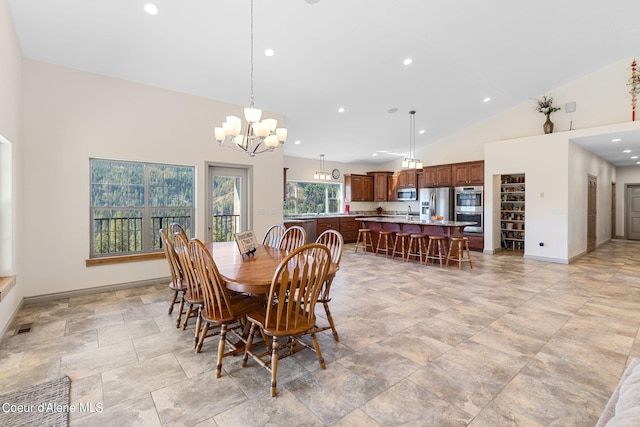 dining space featuring sink, a notable chandelier, high vaulted ceiling, and light tile flooring