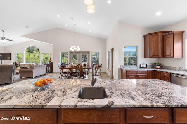 kitchen featuring plenty of natural light, pendant lighting, ceiling fan with notable chandelier, and sink