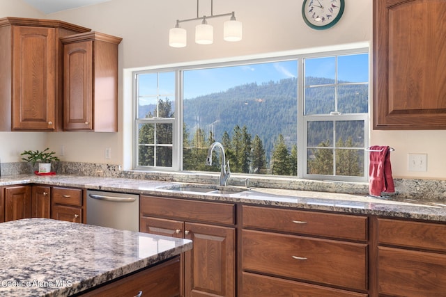 kitchen featuring stainless steel dishwasher, a healthy amount of sunlight, sink, and decorative light fixtures