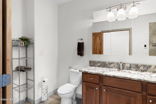 bathroom with toilet, tile floors, and vanity