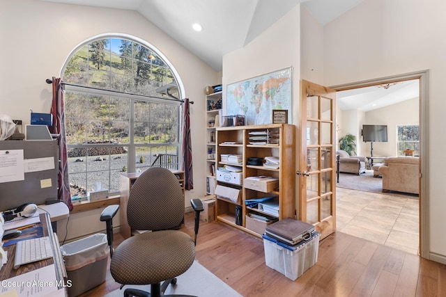 home office featuring plenty of natural light, light tile floors, and lofted ceiling