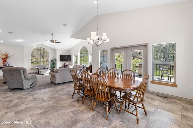 tiled dining area featuring a healthy amount of sunlight, french doors, high vaulted ceiling, and ceiling fan with notable chandelier