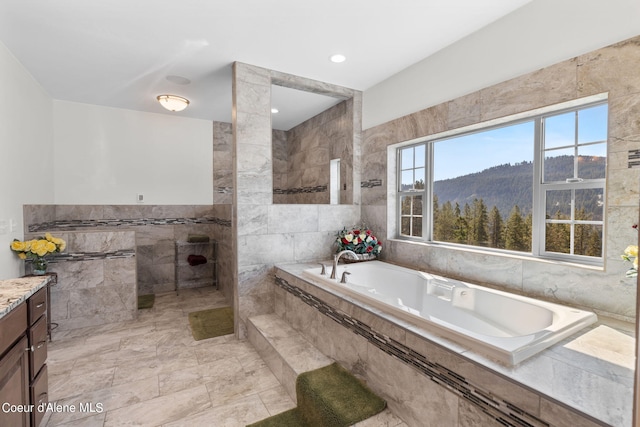 bathroom featuring tile flooring, tile walls, a mountain view, vanity, and shower with separate bathtub