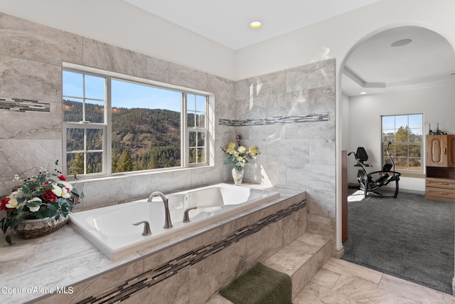 bathroom featuring tiled bath, tile walls, and tile floors