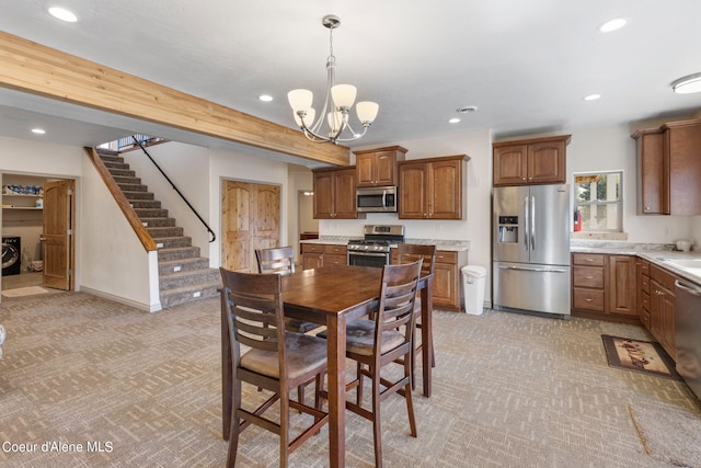 dining space featuring a notable chandelier, sink, and light carpet