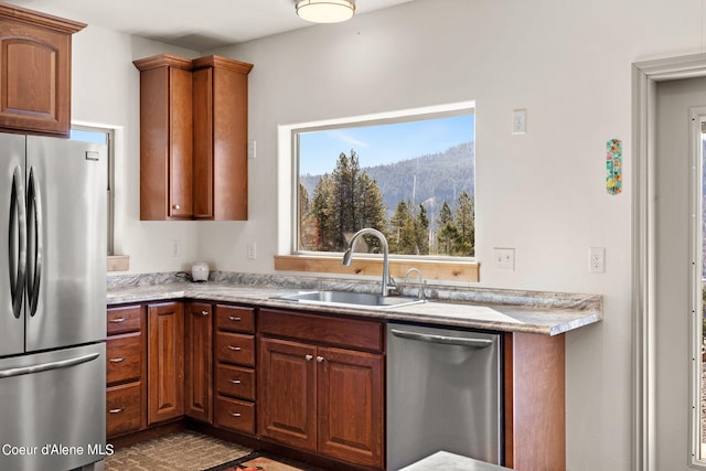 kitchen featuring appliances with stainless steel finishes, light stone countertops, and sink