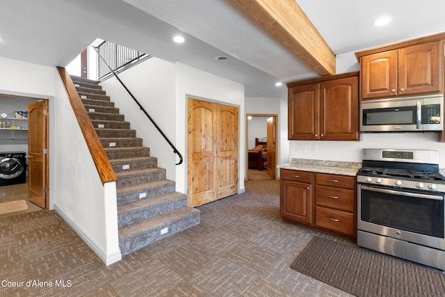 kitchen featuring beamed ceiling, wood counters, stainless steel appliances, dark carpet, and washer / clothes dryer