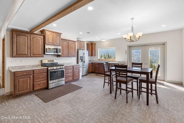 kitchen featuring beamed ceiling, light colored carpet, stainless steel appliances, a notable chandelier, and pendant lighting