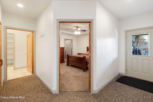 foyer featuring dark colored carpet and ceiling fan