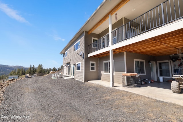 view of property exterior featuring a balcony and a patio