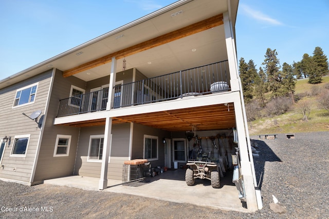 rear view of property with a balcony and a patio area