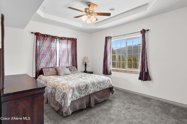 bedroom featuring ceiling fan, carpet flooring, and a tray ceiling