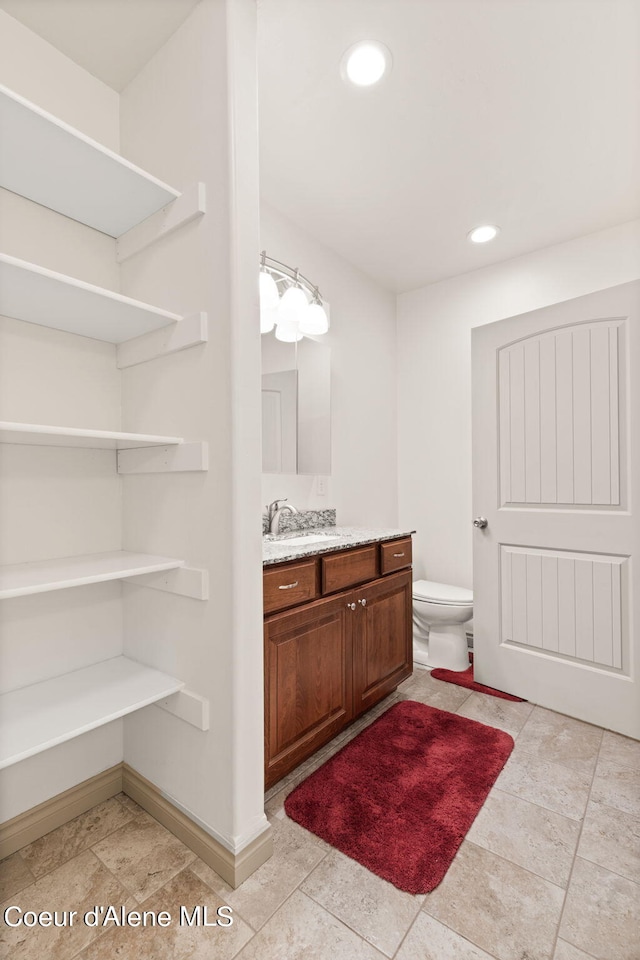 bathroom with tile floors, toilet, and vanity