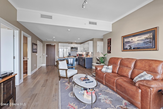 living room featuring track lighting and light hardwood / wood-style flooring