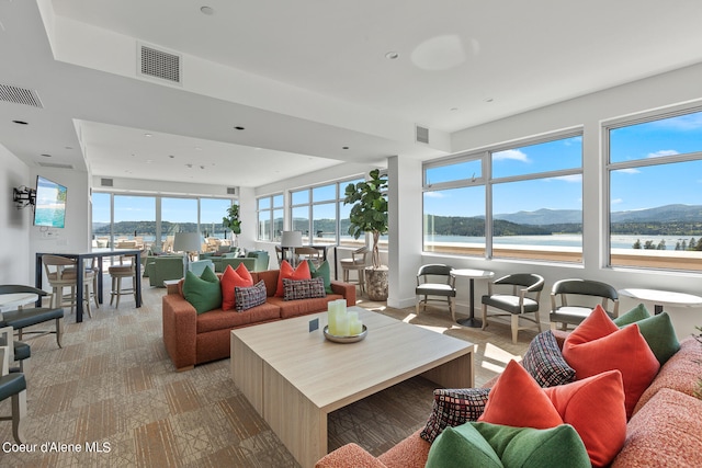 living room featuring a water and mountain view and light wood-type flooring