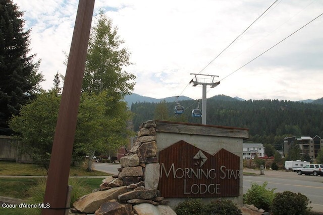 community / neighborhood sign with a mountain view