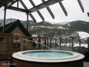 snow covered pool with a mountain view and a hot tub