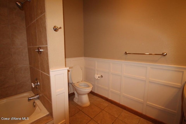 bathroom with toilet, tile floors, and tiled shower / bath combo