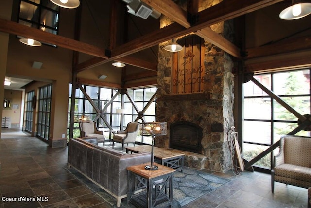 tiled living room with high vaulted ceiling, beam ceiling, and a stone fireplace