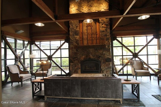 tiled living room featuring beamed ceiling and a fireplace