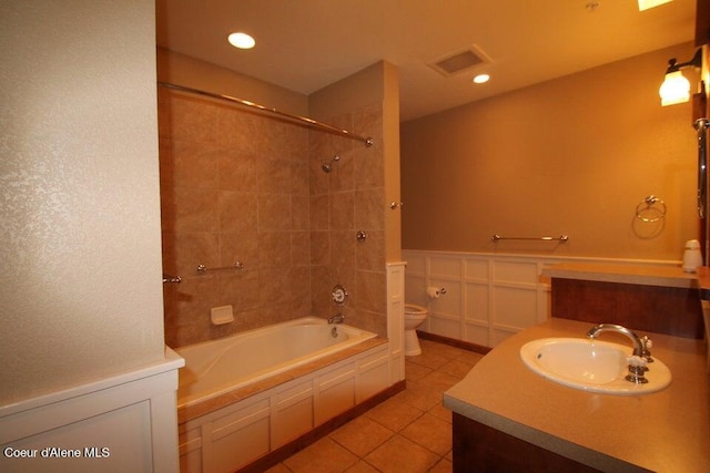 full bathroom featuring tiled shower / bath combo, toilet, tile floors, and vanity