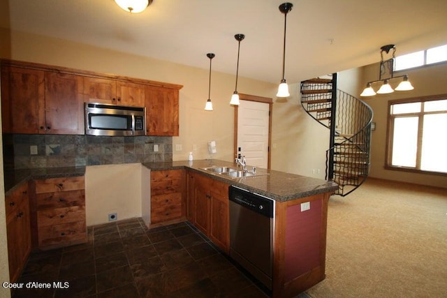 kitchen featuring sink, dark tile flooring, decorative light fixtures, stainless steel appliances, and kitchen peninsula