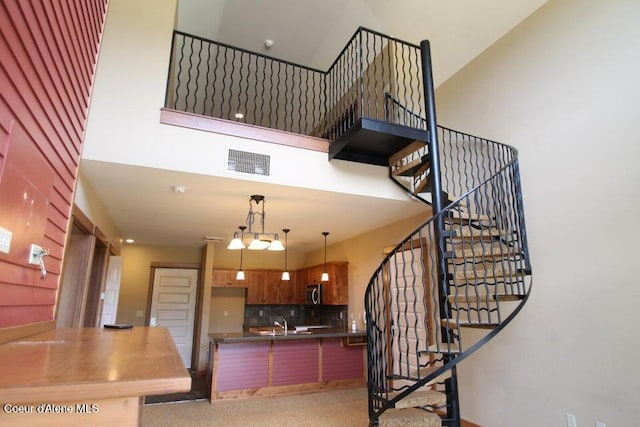 stairs with sink and a high ceiling