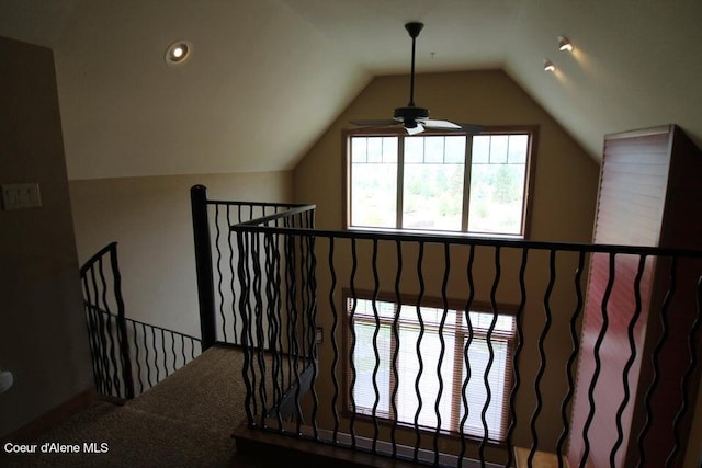 interior space featuring ceiling fan, carpet floors, and lofted ceiling