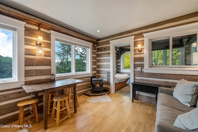 interior space featuring rustic walls, a wood stove, and light wood-type flooring