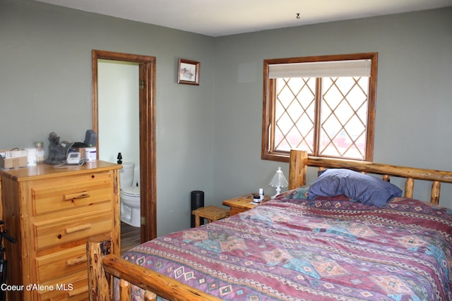 bedroom featuring hardwood / wood-style flooring and connected bathroom