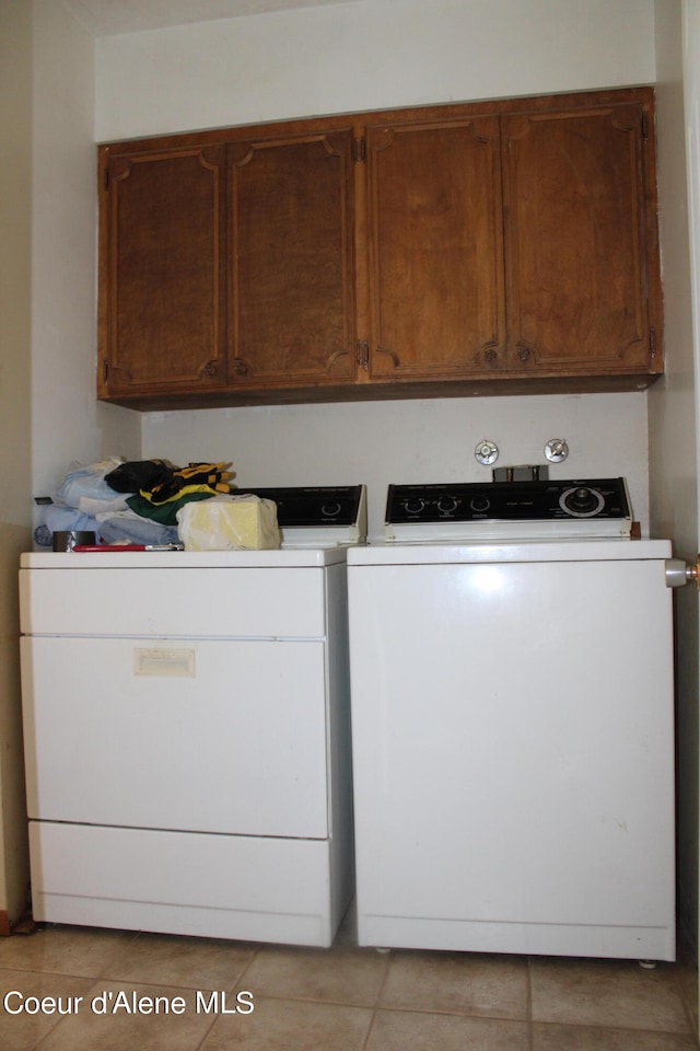 laundry area featuring washer hookup, cabinets, light tile floors, and washer and dryer