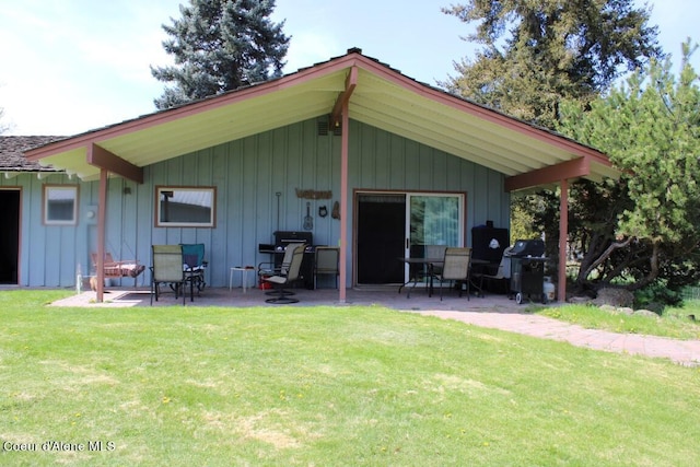 back of house with a patio and a lawn