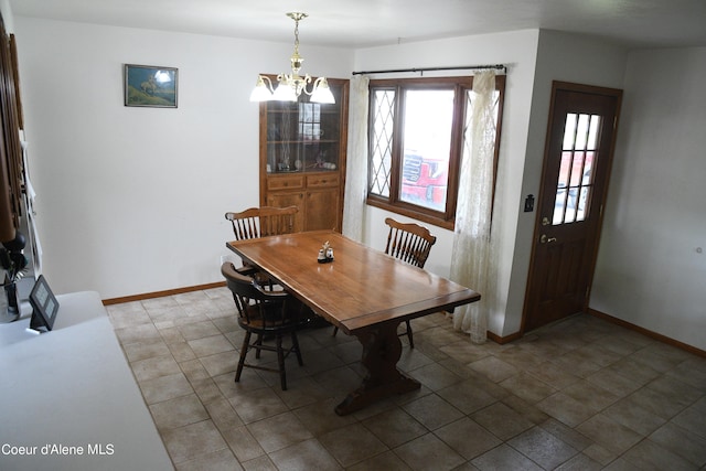 dining room featuring tile floors and an inviting chandelier