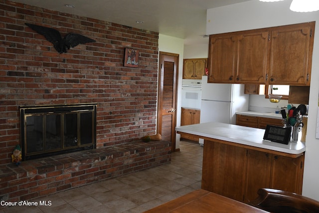 kitchen featuring a fireplace, white appliances, brick wall, and tile flooring