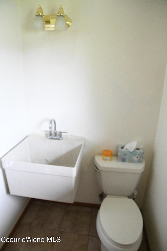 bathroom featuring sink, toilet, and tile flooring