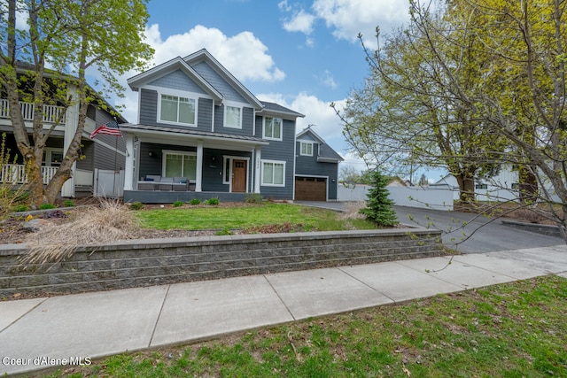 craftsman-style house with a garage, covered porch, and a front yard