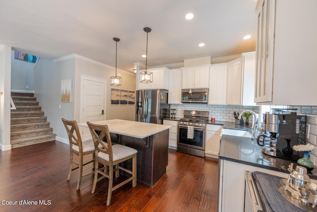 kitchen featuring backsplash, stainless steel appliances, sink, dark hardwood / wood-style flooring, and a center island