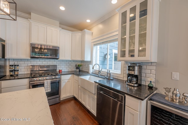 kitchen featuring backsplash, sink, stainless steel appliances, and dark stone counters