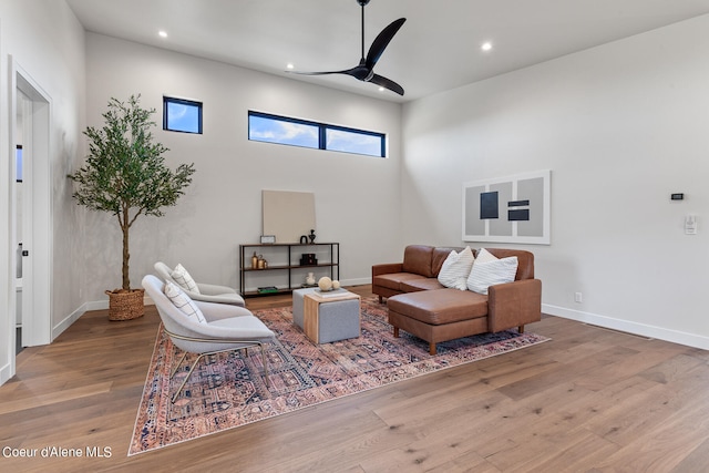 living room featuring ceiling fan and hardwood / wood-style flooring