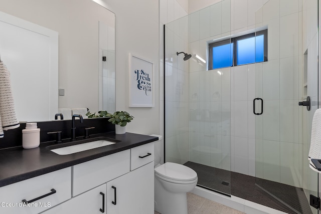 bathroom with vanity, tile patterned flooring, toilet, and a shower with door