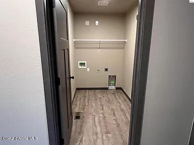 washroom with light hardwood / wood-style floors, electric dryer hookup, and hookup for a washing machine