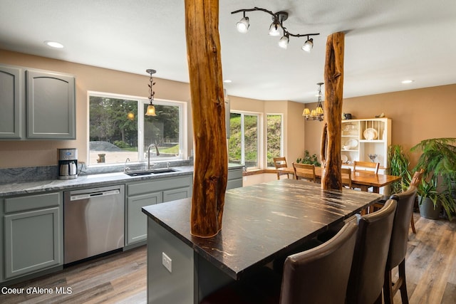 kitchen featuring hardwood / wood-style flooring, dishwasher, sink, and hanging light fixtures