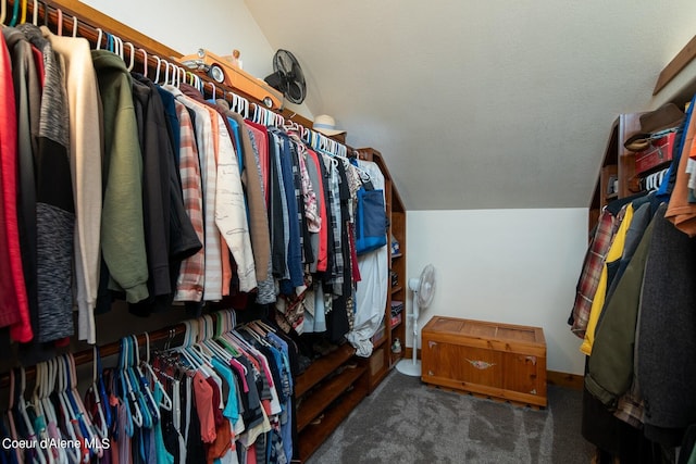 walk in closet featuring lofted ceiling and dark carpet