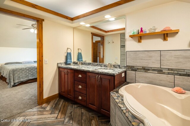 bathroom with ceiling fan, vanity with extensive cabinet space, tile walls, dual sinks, and a bathtub